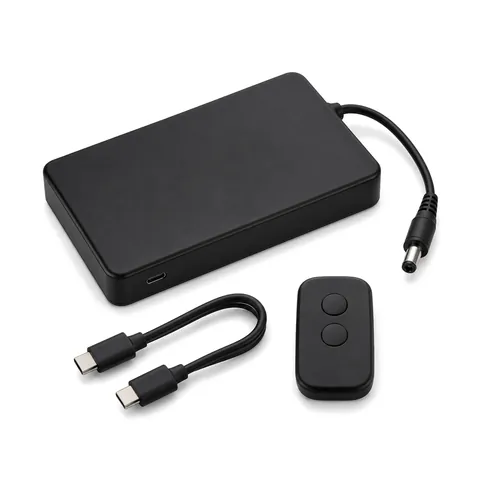 Caja de batería recargable negra con cable de CC, cable USB-C corto y control remoto de dos botones, fondo blanco