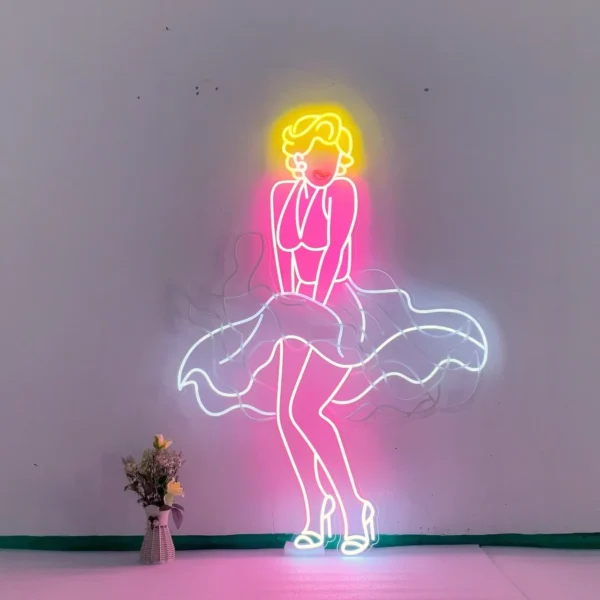 Neon sign depicting a stylized figure of Marilyn Monroe in her iconic pose with a flowing dress. The sign features bright colors, with yellow for her hair, pink for her dress and body, and white for the dress details and shoes.