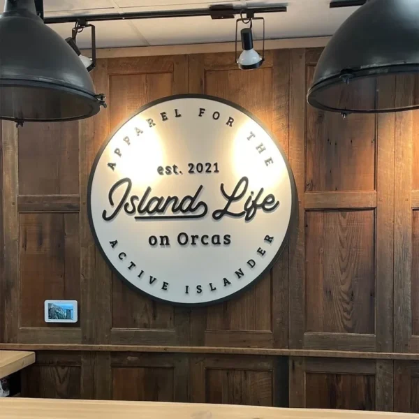 A round illuminated sign on a wooden wall.