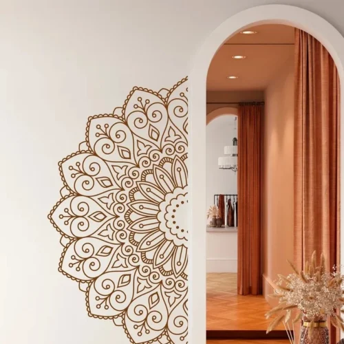 A detailed brown mandala design is painted on a white wall, partially visible through a white arched doorway. The background features an interior space with terracotta-colored curtains and warm lighting. The elegant design adds a decorative touch to the modern and stylish room.