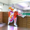 Neon sign of a cowgirl sitting on a stack of boxes. The cowgirl is dressed in a white hat, white boots, and a fringed outfit with vibrant red, blue, and white neon lights. The sign is displayed indoors.