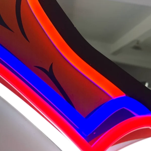 Close-up of the neon sign showing the detailed red, blue, and white neon lights outlining the cowgirl's outfit, highlighting the quality and brightness of the neon tubes.