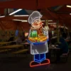 Neon sign of a cheerful chef holding a tray with a burger, fries, and a drink, set in a food court.