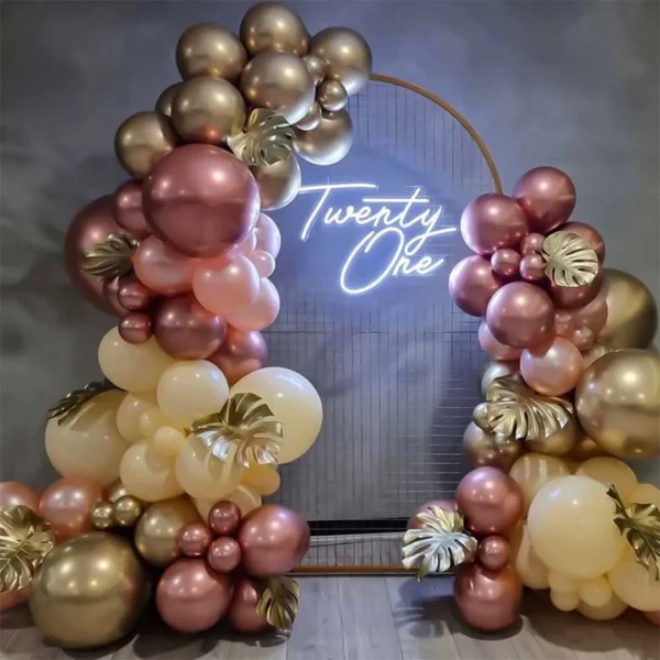 Balloon arch in gold, rose gold, and cream with a neon sign reading "Twenty One" on a circular wire backdrop.